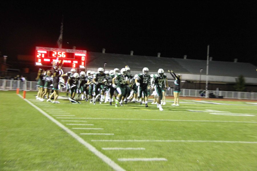 Paly+varsity+football+team+storming+the+field+to+play+for+the+second+half.
