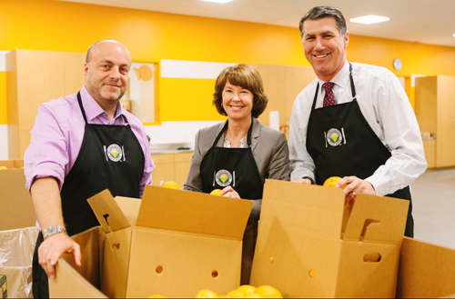 Members of the Second Harvest Food Bank of Santa Clara and San Mateo counties unpack oranges in order to prepare for the 2013 holiday food and fund drive.  