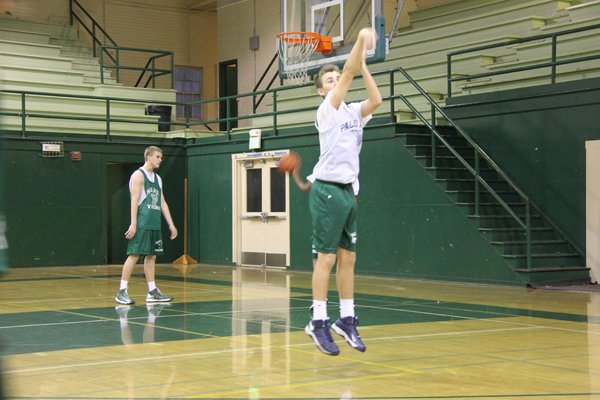 Junior Jonathan Rojahn takes a three-point shot during practice in the gym.