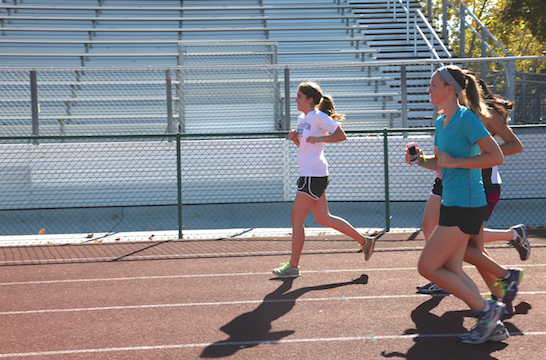 The cross country girls run on the track at practice to prepare for an upcoming meet.