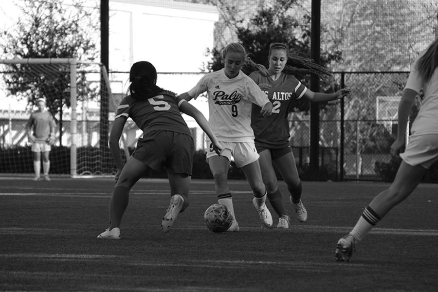 Varsity player Ansley Queen attempts to drive through two defending girls from Los Altos. The Paly girls team won the game 2-0.
