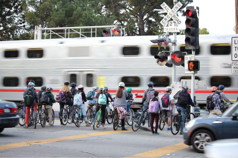 Students+who+bike+to+school+illegally+crowd+at+the+Alma+and+Churchill+intersection+after+a+train+triggers+a+red+light+for+traffic.