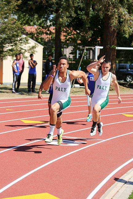 Junior Austin Cox passes the baton to junior Eli Givens during the 4x400 meter relay, helping boys varsity track and field win the race and beat Los Altos 66-61 on April 23. 
