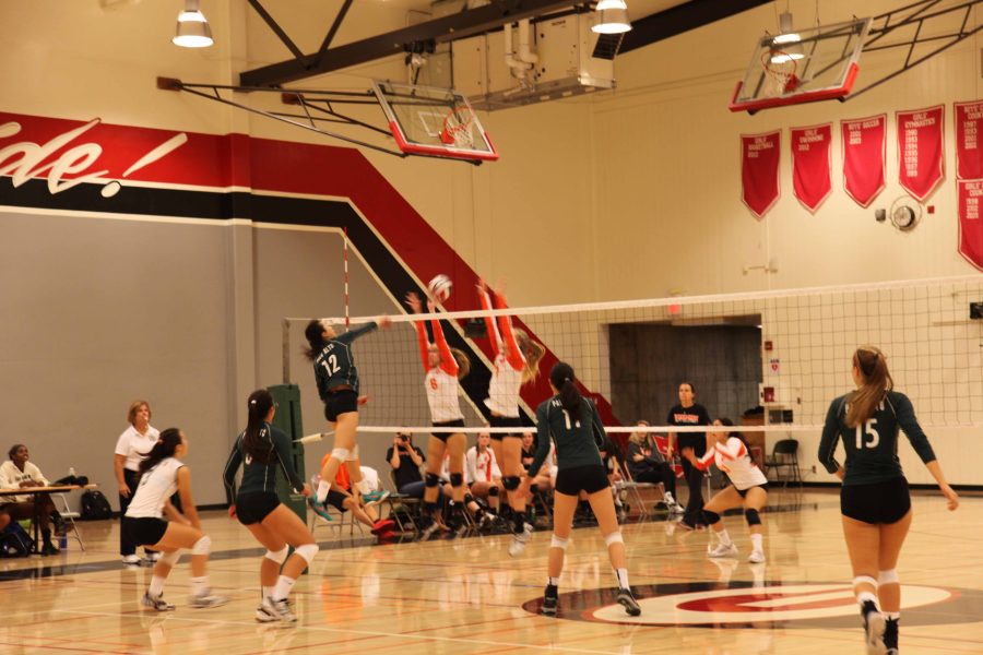 Sophmore Chelesea Fan hits the ball past Woodside blockers in the team’s home opener. Fan led the team with 11 kills in the preseason victory against the Wildcats.