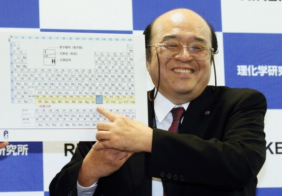 Kosuke Morita, the head researcher of the Japanese team, poses with updated periodic table featuring his discovery of element 113.