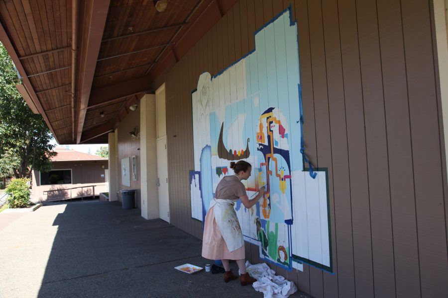Senior Karen Bowman paints the mural on Student Center to be finished next year.