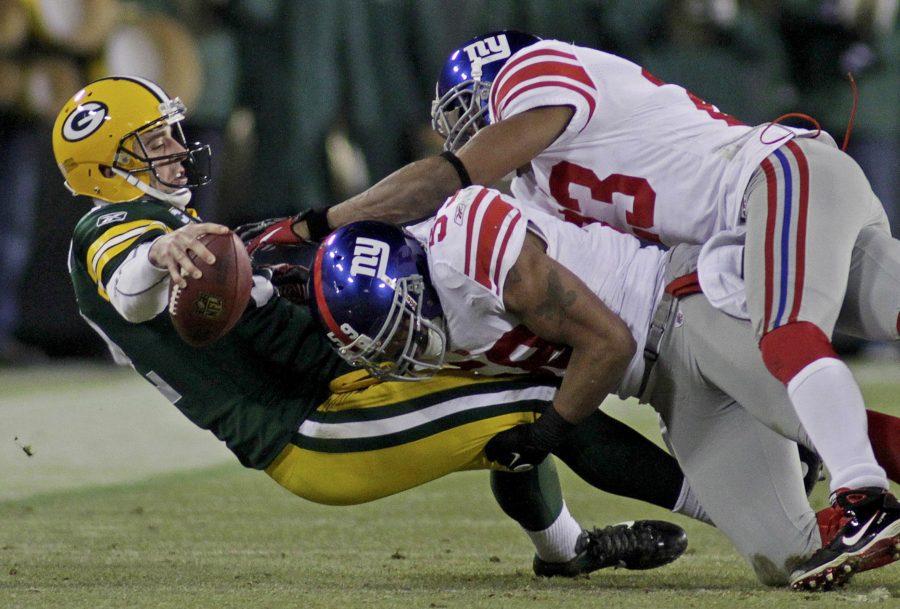 Green Bay Packers quarterback Aaron Rodgers (L) is tackled by New York Giants Michael Boley (C) and Corey Webster (R) in the third quarter during their NFL NFC Divisional playoff football game in Green Bay, Wisconsin, January 15, 2012.  REUTERS/Darren Hauck (UNITED STATES  - Tags: SPORT FOOTBALL)