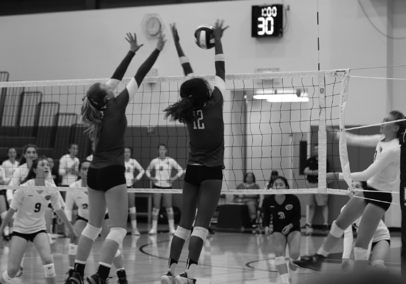 Focused and determined, senior Siena Brewster and junior Amelia Gibbs  block an opponent’s spike.