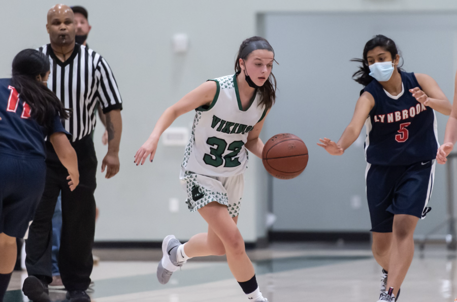 Junior Grace Corrigan fends off a defender in a Paly basketball game. Juggling demanding sports schedules and school workloads have proven difficult for athletes like Corrigan. “I have considered quitting a lot recently,” Corrigan said. “What’s stopping me is myself.”