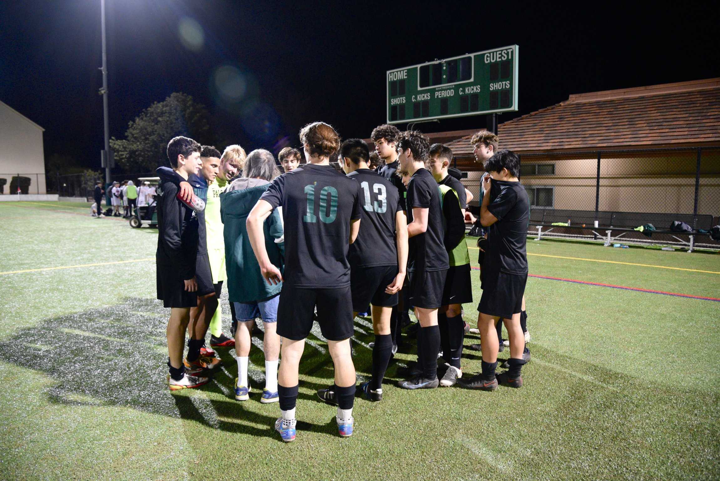 The boys soccer team huddles on the field after its 2-1 victory against Gunn High School on Feb. 16. Photo by Emily Yao