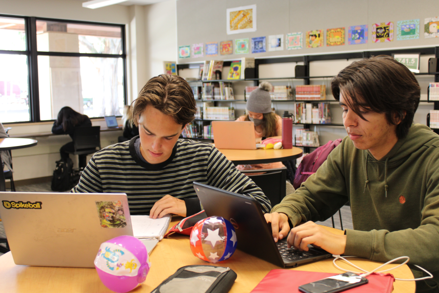 Senior Sebastian Accetta works in the library while unmasked. Palo Alto Unified School District ended its mask mandate on March 11. Photo by Ken Ogata
