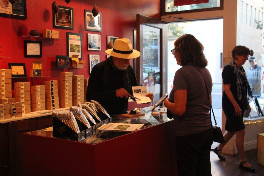 Panos Panagos helps a customer choose organic and sustainably grown chocolates in Alegio Chocolate, located at 552 Bryant St in
downtown Palo Alto. “At the end of the day, the quality of the chocolate starts from the work on the plantations,” Panagos said. Photo by Gabriella Gulman