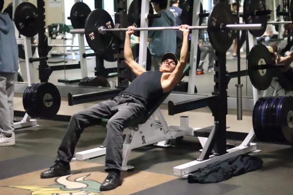 Junior Ramses Luna lifts a bar off the rack. “By having strength in power, mobility and flexibility, it will enable (student athletes) to decrease injuries and to have a competitive edge,” Butler said.