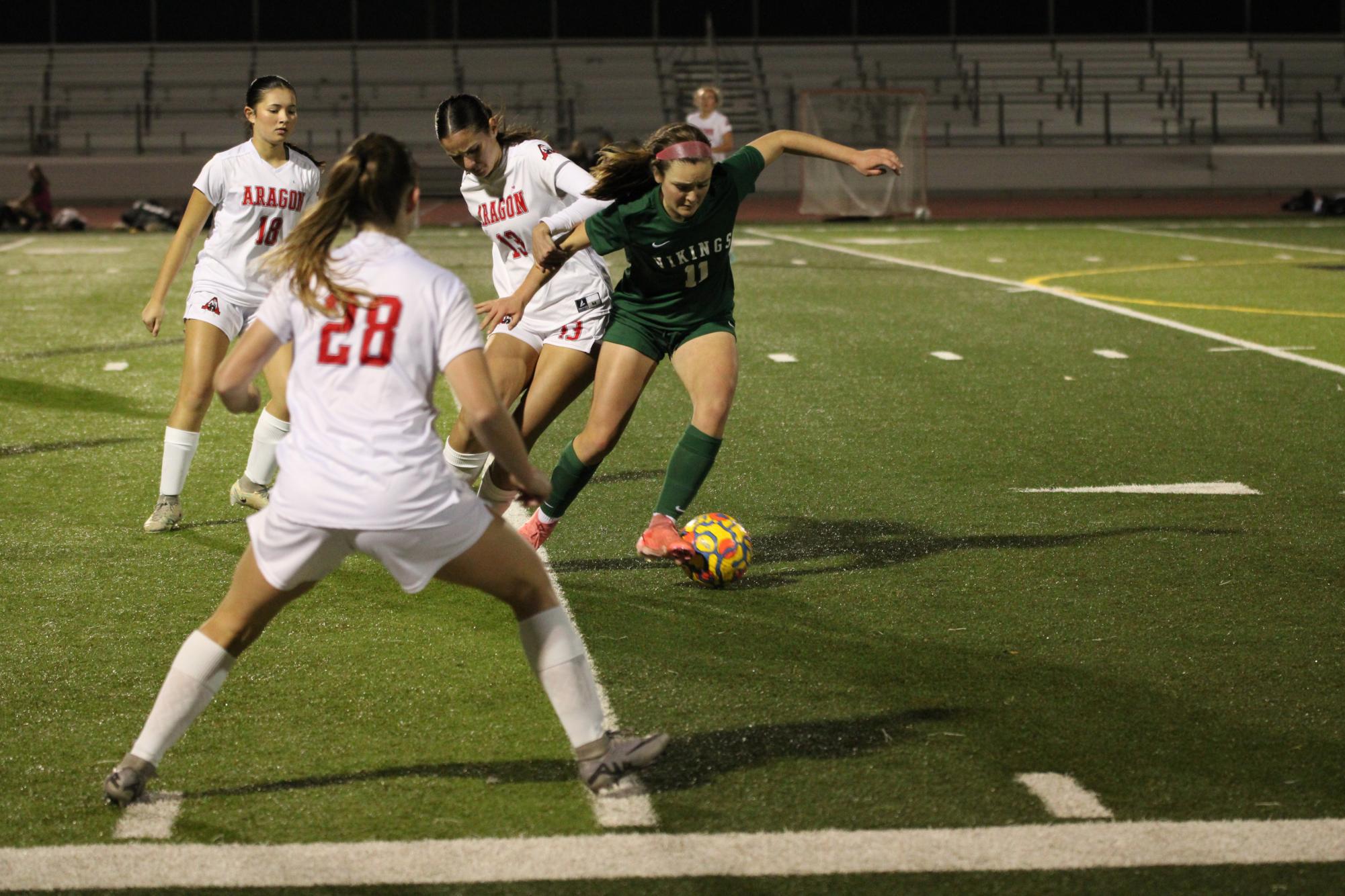 Senior Kaitlin Lowry dribbles around defenders in the preseason loss against Aragon. "This is our first game of the season," senior and captain Polina van Hulsen said. "There's always room for improvement, and I think that we could bring that out in the rest of our games."