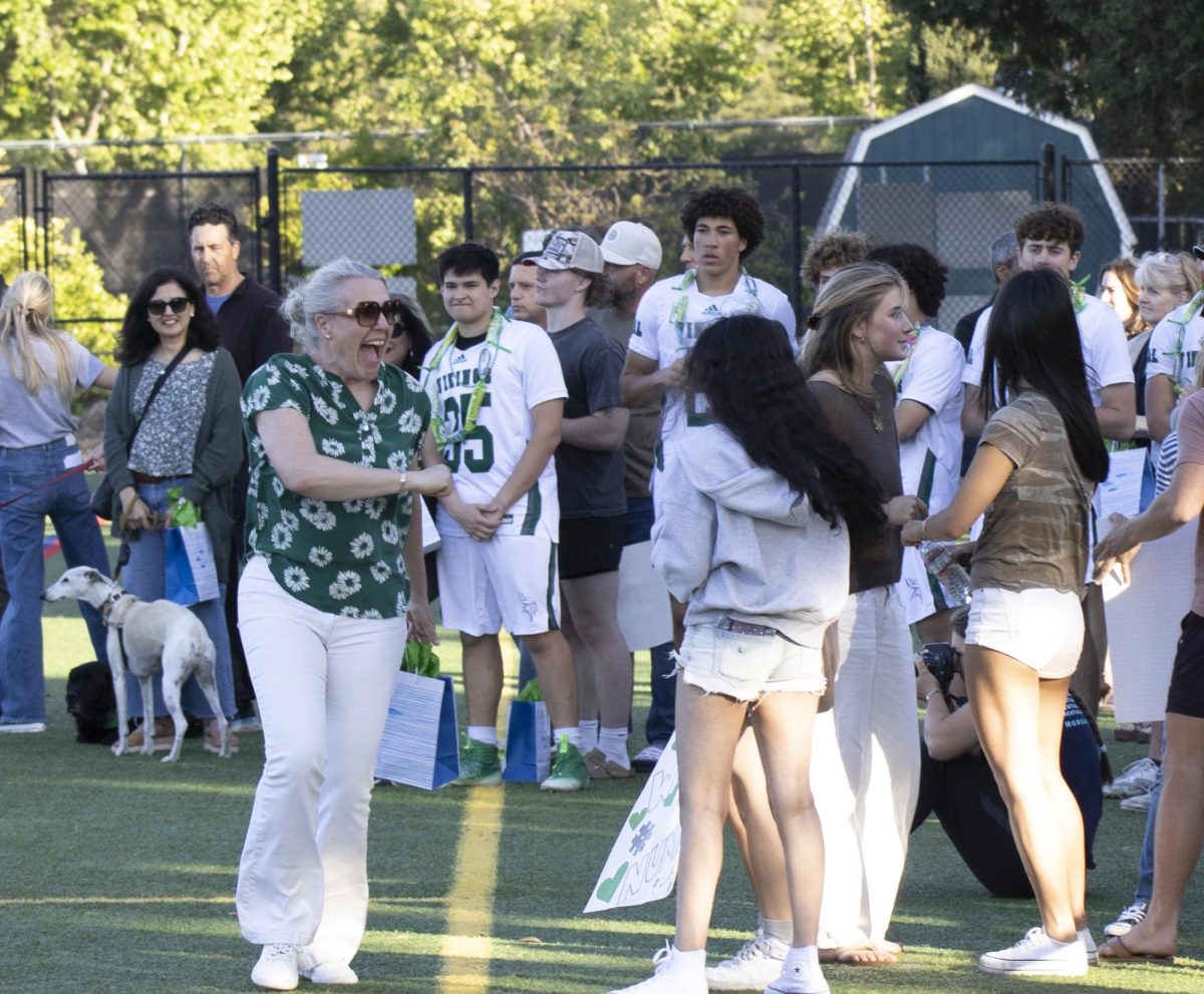 Parent Nana Chancellor celebrates with fans following the senior night ceremony.